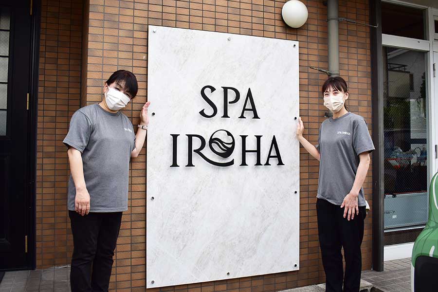 屋外サインの前で立つスタッフ